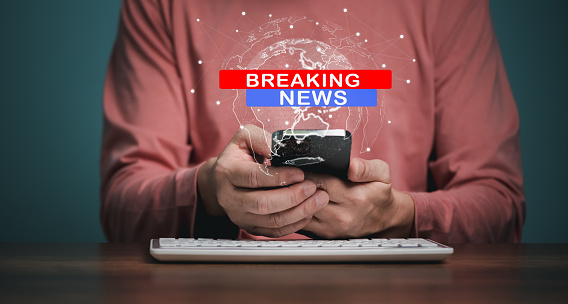 Breaking News, broadcast channels or internet tv concept, Man holding Mobile phone with World Global news background design.