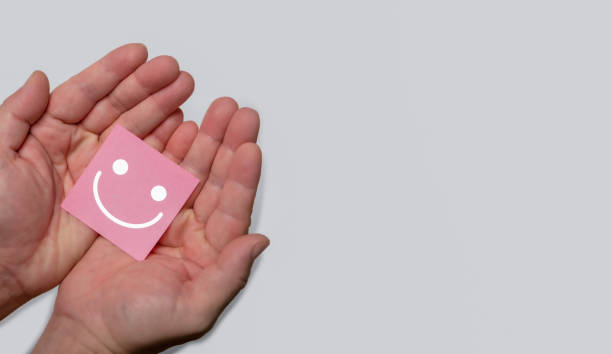 istock Customer review satisfaction concept, Hand holding Positive emotion smiling face icon with copy space. 1436078564