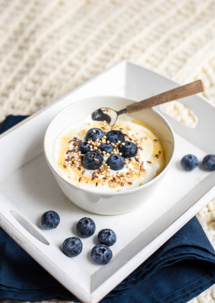 Healthy breakfast bowl with yoghurt muesli and quinoa linseed blueberry honey topping stock photo