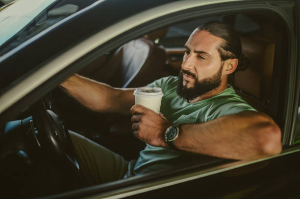 istock Young brunette sitting in a car and having coffee 1436081215
