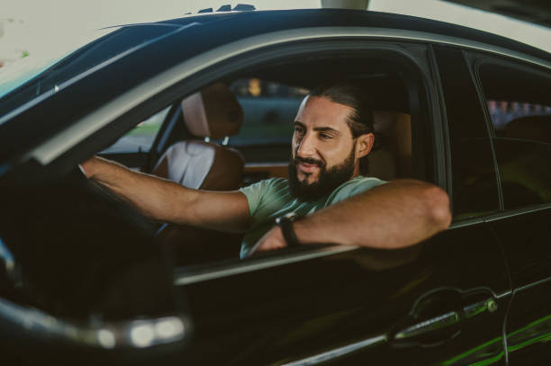 istock Young brunette sitting in a car and looking confident 1436081217