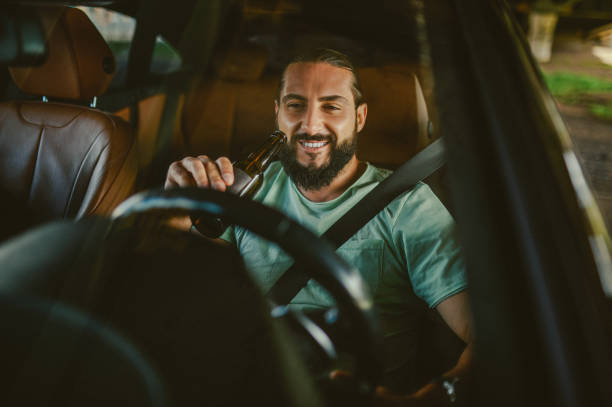 istock Young handsome dark-haired man driving a car and smiling 1436081224