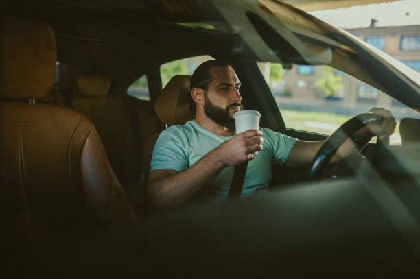 istock Young brunette sitting in a car and looking confident 1436081242