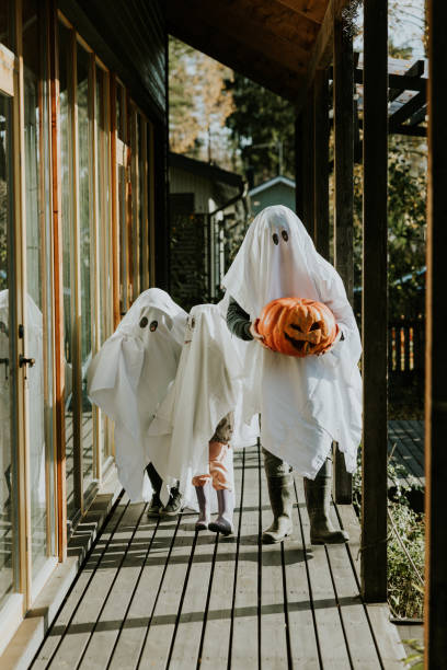 istock Mother, Father and daughter playing ghosts during Halloween 1436081965