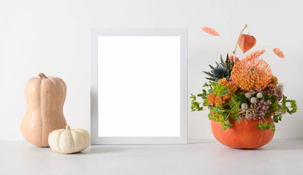 istock Autumn mockup with flowers bouquet in pumpkin, decor elements and white frame. 1436082010