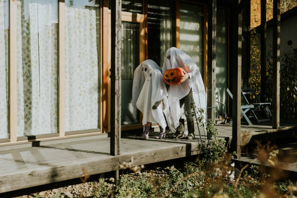 istock Mother, Father and daughter playing ghosts during Halloween 1436082027