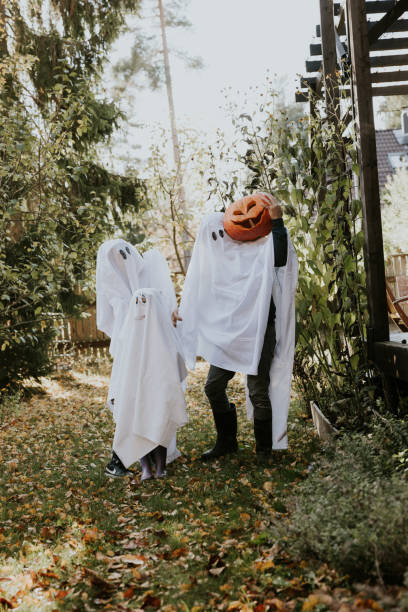 istock Mother, Father and daughter playing ghosts during Halloween 1436082078