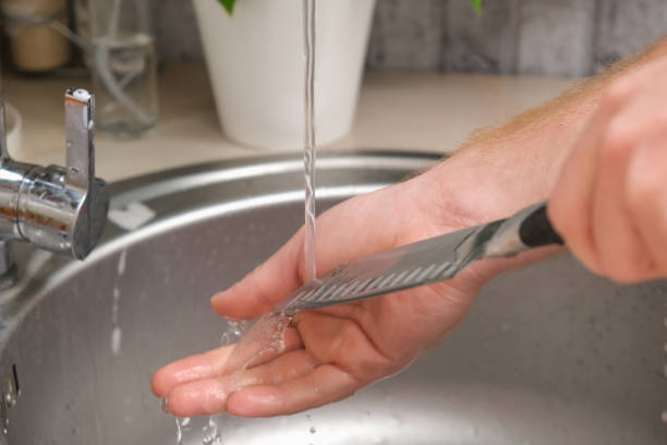 istock A man washes sharp steel dirty kitchen knife with a sponge with detergent in the kitchen sink under running water. Gentle hand washing of the kitchen knife. Cleaning of dirty sharp metal products. 1436083078