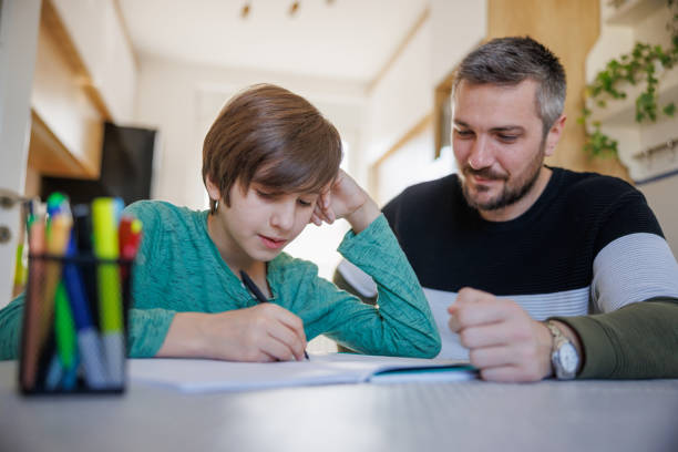 istock Father sitting with his elementary aged boy and giving support in learning 1436083355