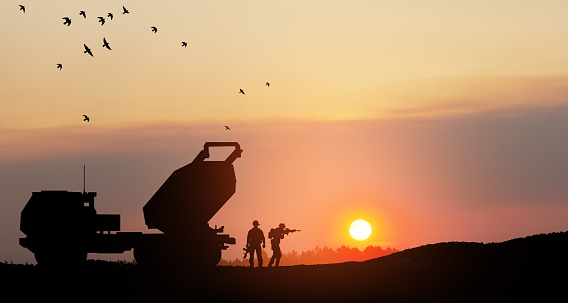 Artillery rocket system are aimed to the sky and soldiers at sunset. Multiple launch rocket system.