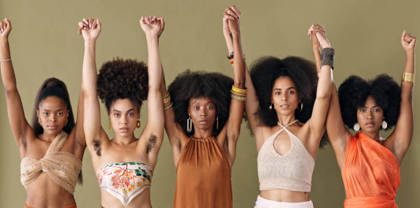 Black women hands raised in freedom, community and support human rights, equality and revolution in studio. Portrait beauty, fearless feminist pride group and power in justice, solidarity and racism