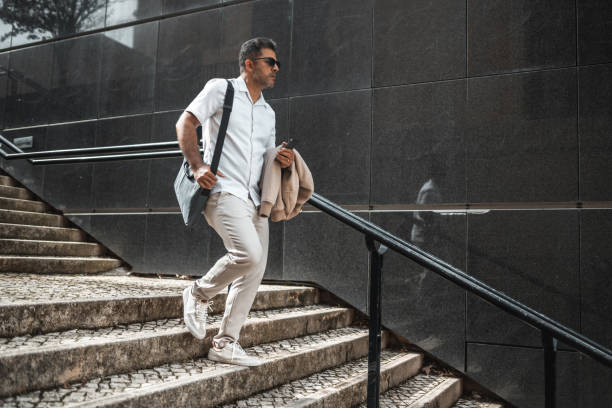 istock Business man walking down the stairs 1436084582