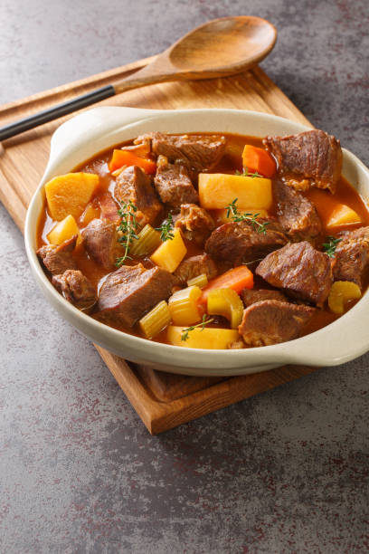 Irish stew stobhach is a stew native to Ireland that is traditionally made with root vegetables and meat closeup in the pot. Vertical stock photo