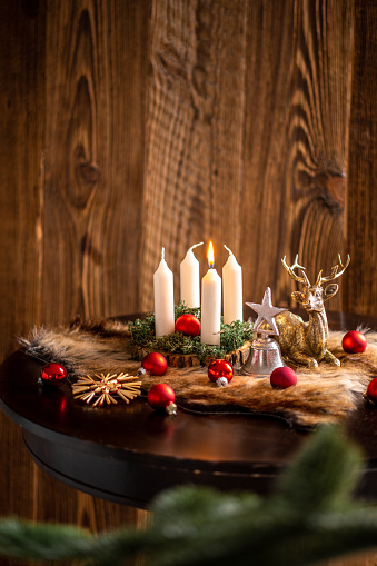 First Advent candle lit up on wreath in German rustic home