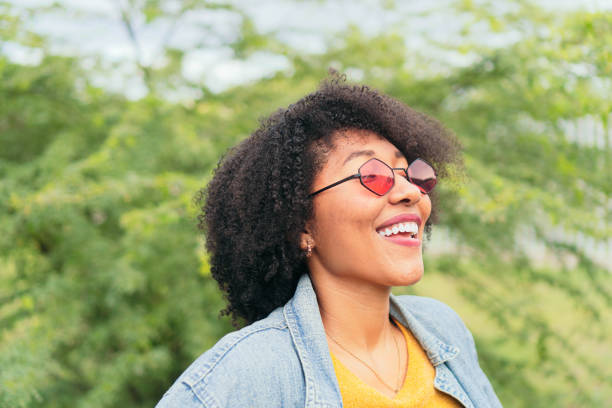 istock Latin Woman looking up and smiling while posing with green plants on background 1436087276