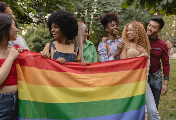 istock Multiracial LGBT friends with rainbow flag 1436091972