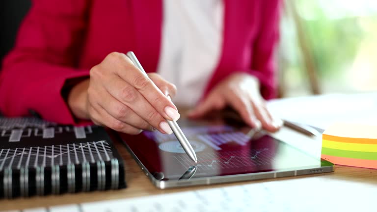 Manager studying chart on digital tablet and making notes with stylus closeup 4k movie slow motion