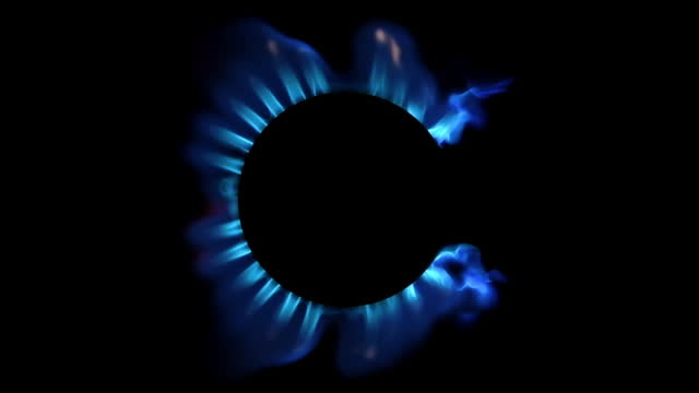Lighting up blue gas in a gas stove top view, on a black background. Slow motion