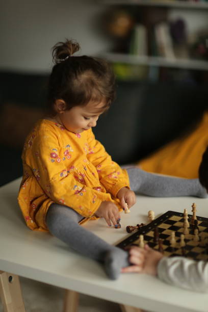 istock Little girl playing chess with her brother 1436098308