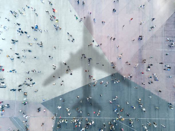 istock Aerial view of crowd with airplane shadow 1436098735