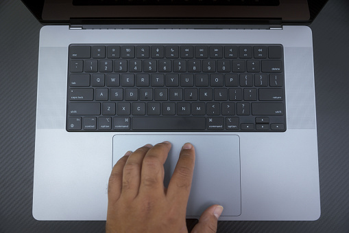 Business details - Close up view Indian man working on a laptop outdoors