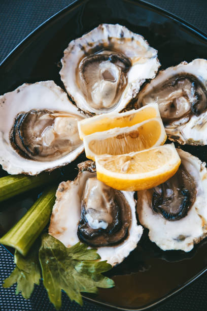 istock Fresh oysters with lemon and celery on a plate 1436100526