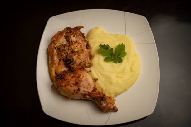 istock Close-up shot of a fried chicken thigh and mashed potatoes on a plate 1436101512