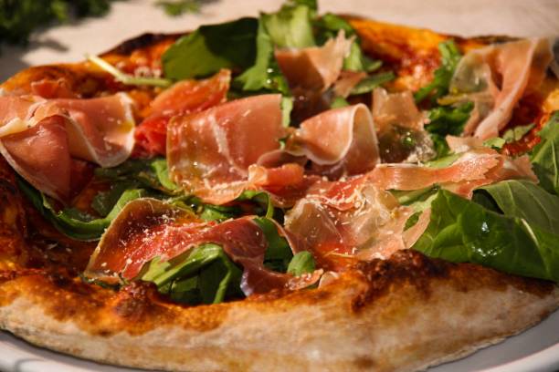 istock Close-up shot of a pizza with prosciutto 1436101516