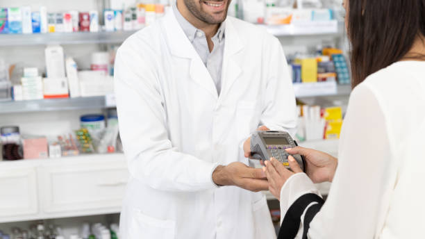 effectuer le paiement - pharmacy credit card pharmacist people photos et images de collection