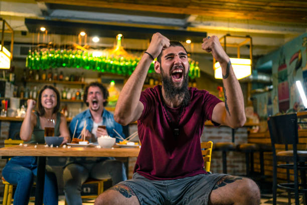istock Young man watching a sports game in a bar 1436106240