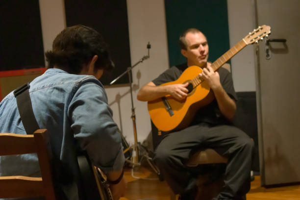istock Student and teacher playing guitar during a class in a music studio 1436108567