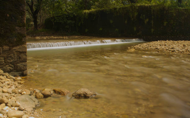 istock Canal water flowing to meet the river 1436112444