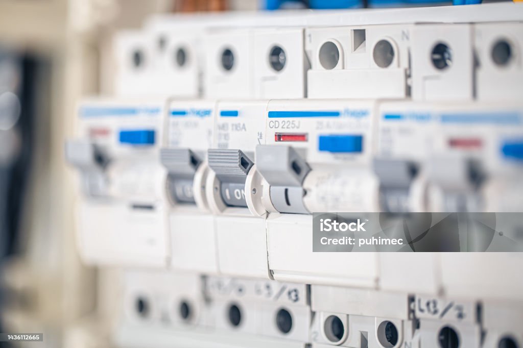 Close up circuit breakers and wire in control panel. Voltage distributor with automatic switches. Electrical background. Electric Switchboard Stock Photo