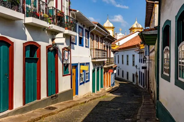 Bucolic street with old colonial-style houses and sunlit cobblestones in the historic city of Ouro Preto in Minas Gerais