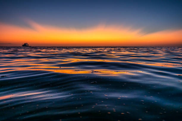 Golden sun rays reflecting on the calm tranquil ocean, Great Barrier Reef, Queensland, Australia.
