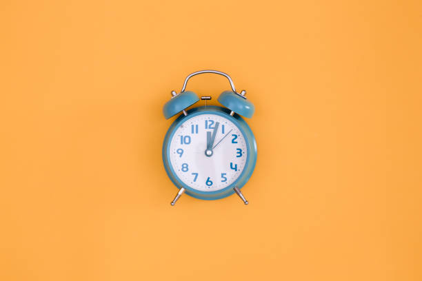 istock Blue alarm clock on orange background isolated, flat lay. 1436118707