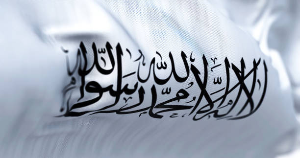 la bandera del emirato islámico de afganistán ondeando en el viento. - sharia fotografías e imágenes de stock