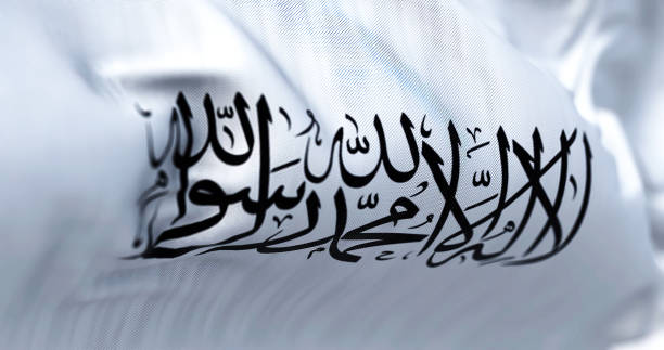 the flag of the islamic emirate of afghanistan waving in the wind. - sharia imagens e fotografias de stock