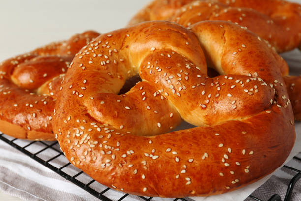 istock Tasty freshly baked pretzels on cooling grid, closeup view 1436123790