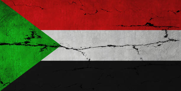 Sudanese Flag on cracked wall background.