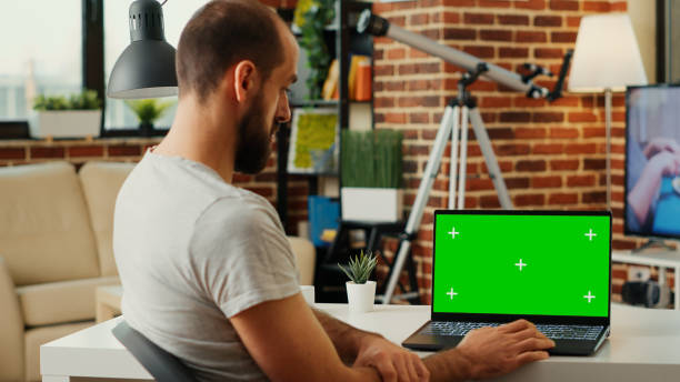 istock Modern manager looking at laptop with greenscreen display 1436125454