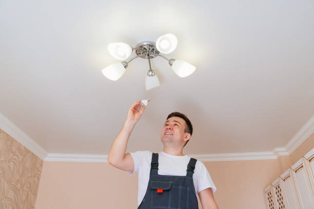 istock A male electrician changes the light bulbs in the ceiling light. 1436125988