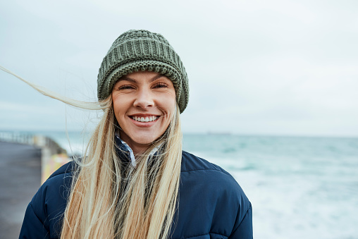 Woman, success or freedom by beach, ocean or sea in Canada with climate change volunteer goals, sustainability target or environment mindset. Portrait, happy smile or marine biologist by nature waves
