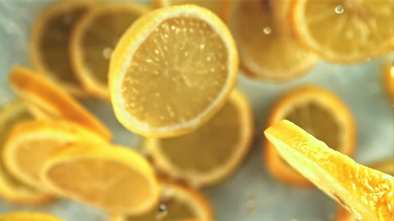 Slices of lemon with drops of water slowly rotate in flight. Top view. Filmed is slow motion 1000 fps.