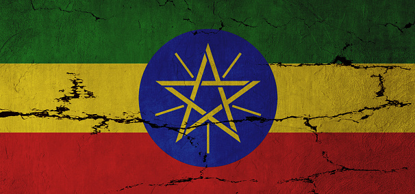Ethiopian Flag on cracked wall background.