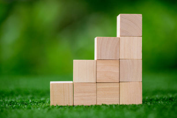istock Stacking blank wooden cubes on green background with copy space for input wording and infographic icon. Empty brown wooden object block for symbol icon put technology, zero gravity, business concept. 1436130845