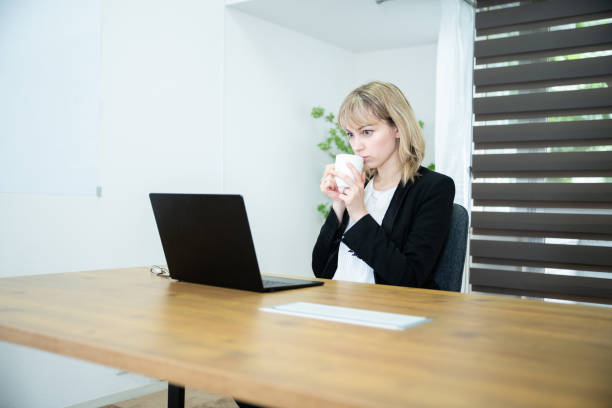 istock An office worker lady drinking coffee at the desk 1436132708