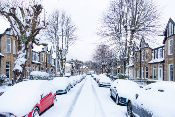 A morning with freshly fallen snow covering the street, cars and houses on a suburban terraced street in Jordanhill, Glasgow.