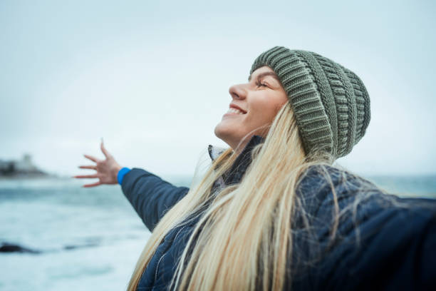 frau, erfolg und freiheit am strand, meer oder meer in kanada mit klimaschutzzielen, nachhaltigkeitsziel und umweltbewusstsein. glückliches lächeln, naturfreiwilliger und meeresbiologe an wasserwellen - klimaschutz stock-fotos und bilder