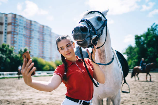 istock Jockey taking selfie with grey mare on smartphone 1436135647